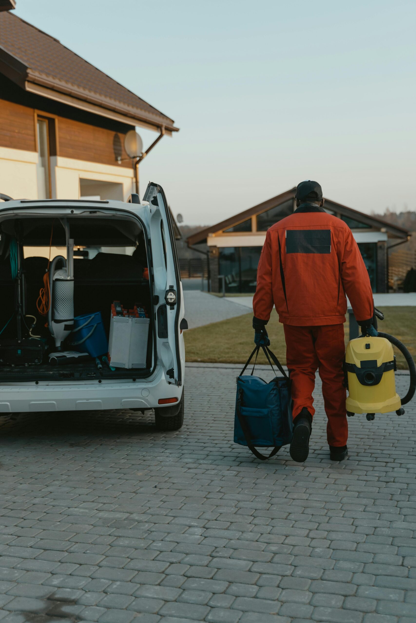 A home service technician carrying equipment to a customer's door